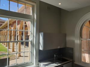 Photo of small sink and cupboards with window overlooking the historic Cloisters.