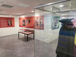 Ira Raymond Exhibition Room displaying academic dress in glass display cabinet