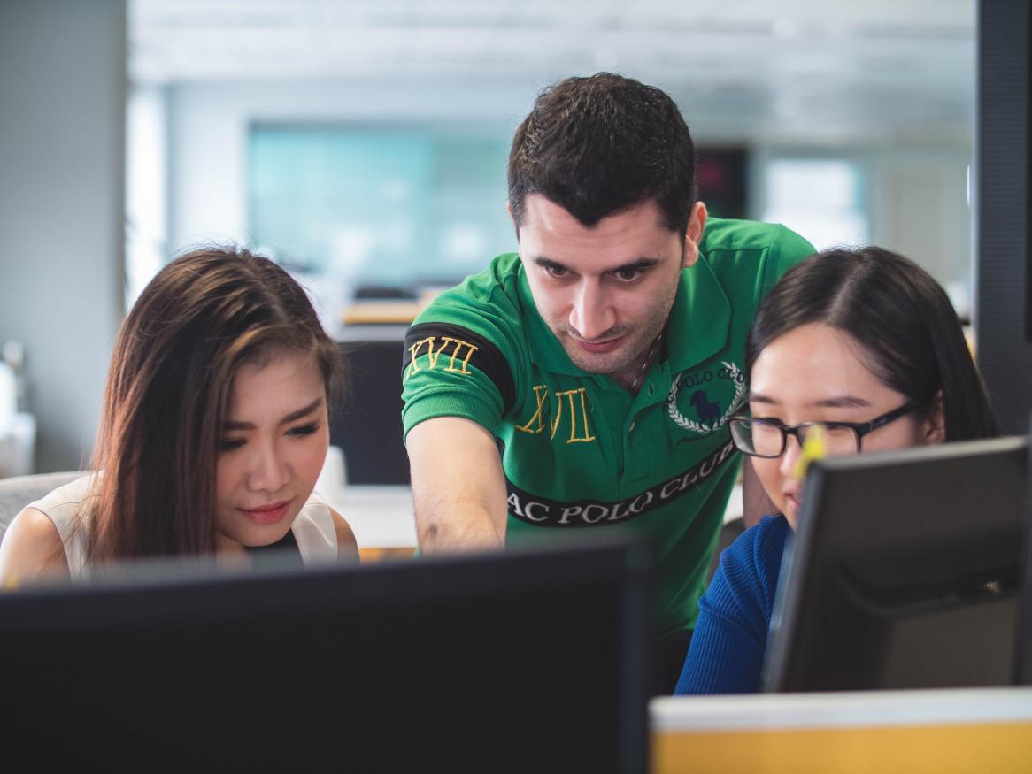 Students and teacher infront of computer