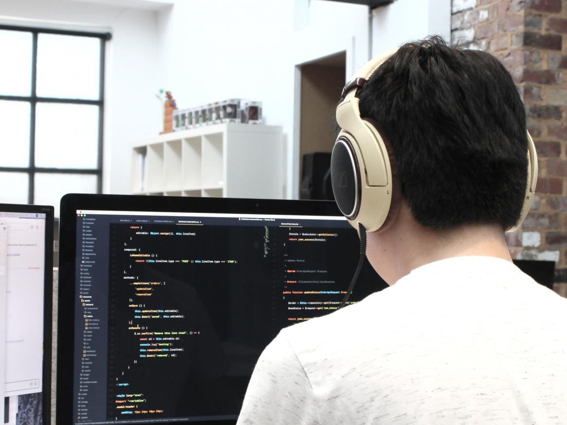 A man wearing headphones is coding