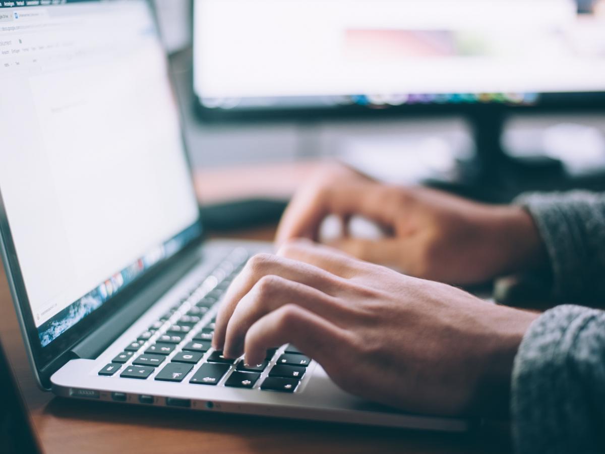 Hands type on a computer