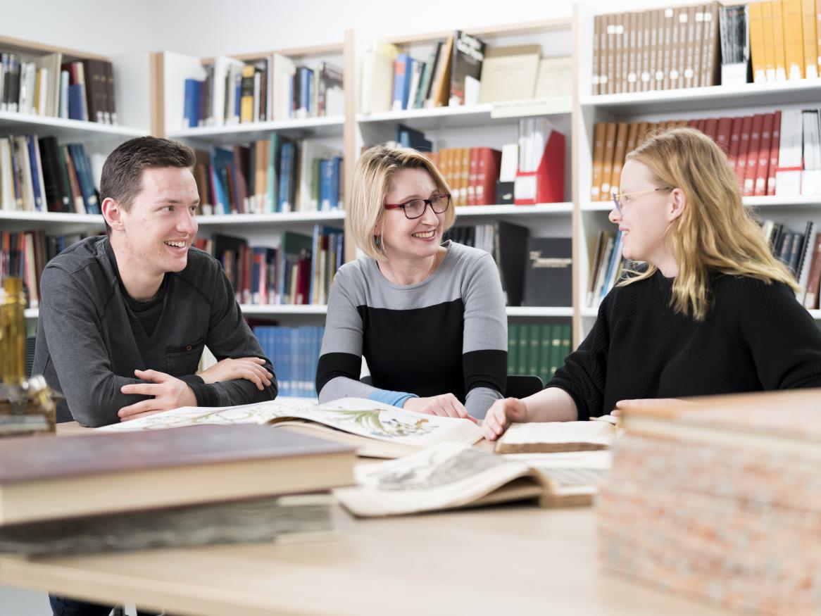 Photo of researcher and students viewing SpARK items