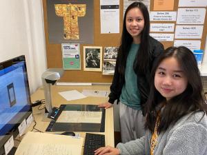 Two student volunteers scanning old documents 