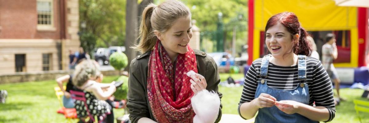 Students on the lawns walking with fairy floss, at an outside event