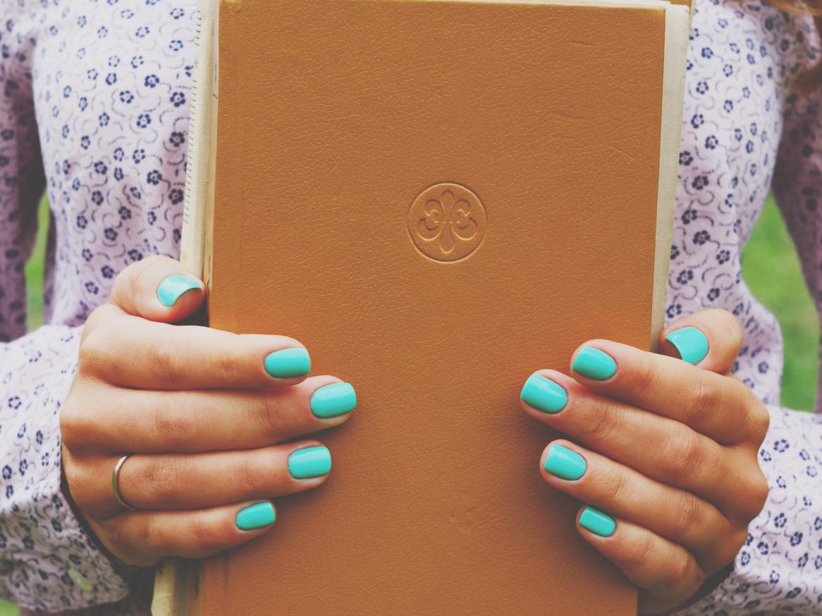 Female student with disturbingly blue nails borrowing some books
