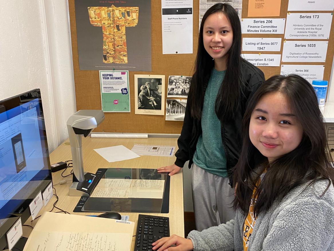 Two students scanning old documents