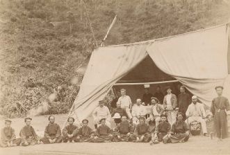 Europeans and Chinese crew beside tent.