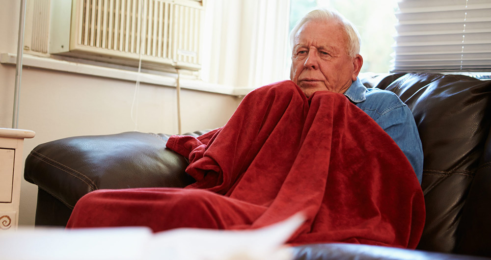 Elderly man keeping warm