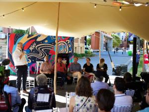 A panel of speakers talking to a crowd