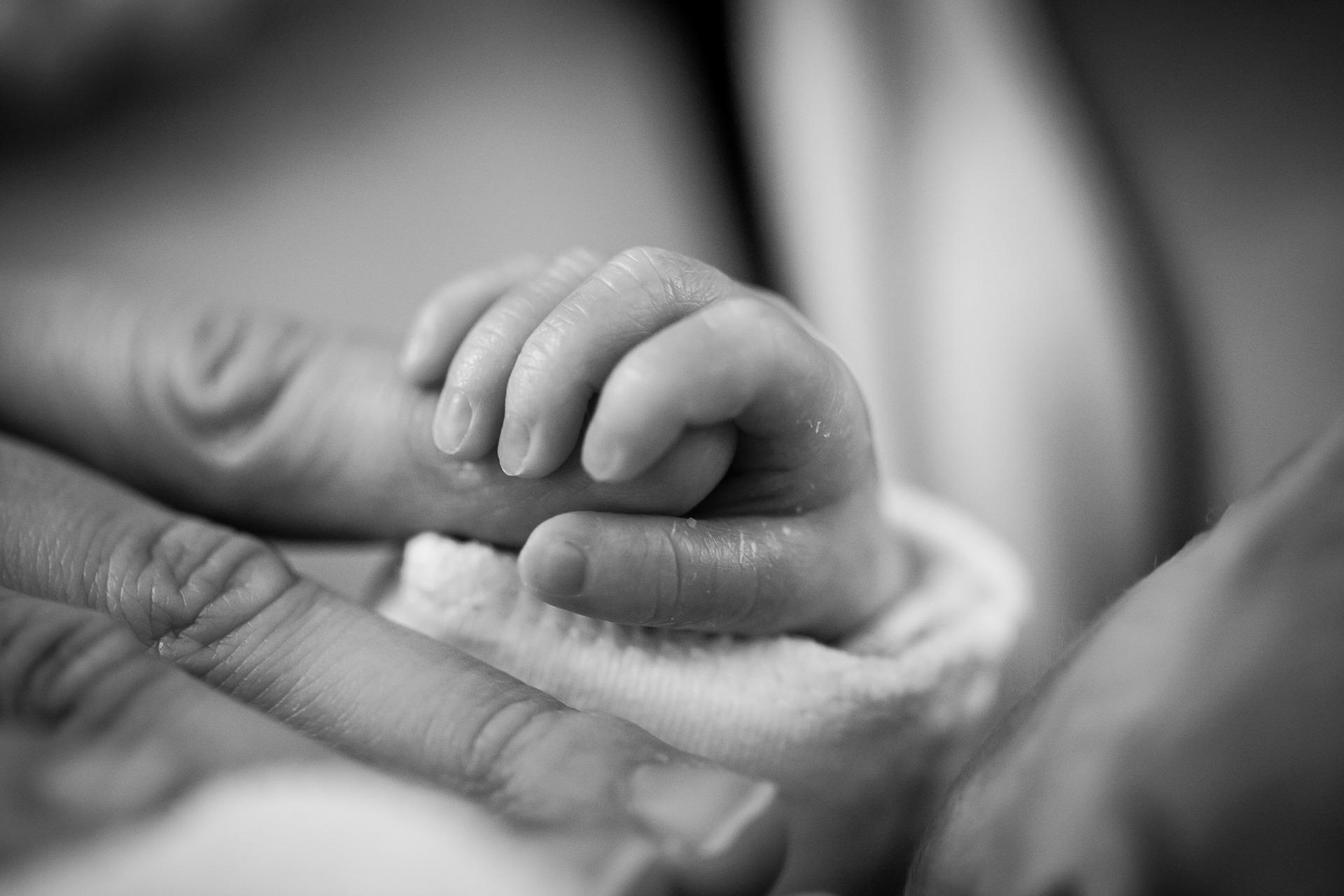 Image of a baby's hand holding a parent finger