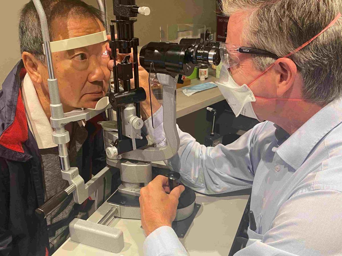 Professor Robert Casson examines a patient's eyes.