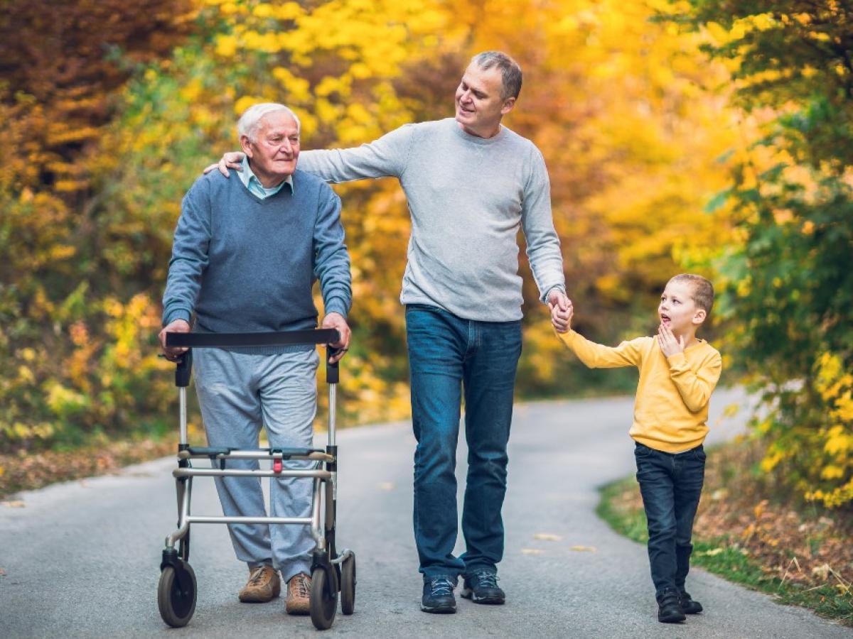 Older man walking with son and grandson