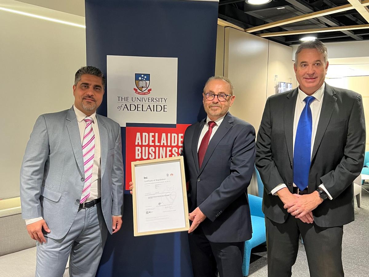 Kiran Bhagat, Professor Noel Lindsay, and Gareth Lloyd smile and display the Certification of Registration.