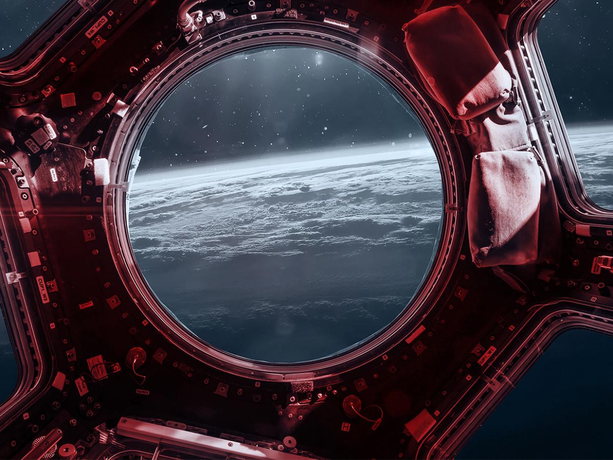 The window of a space shuttle shows the view of a planet.