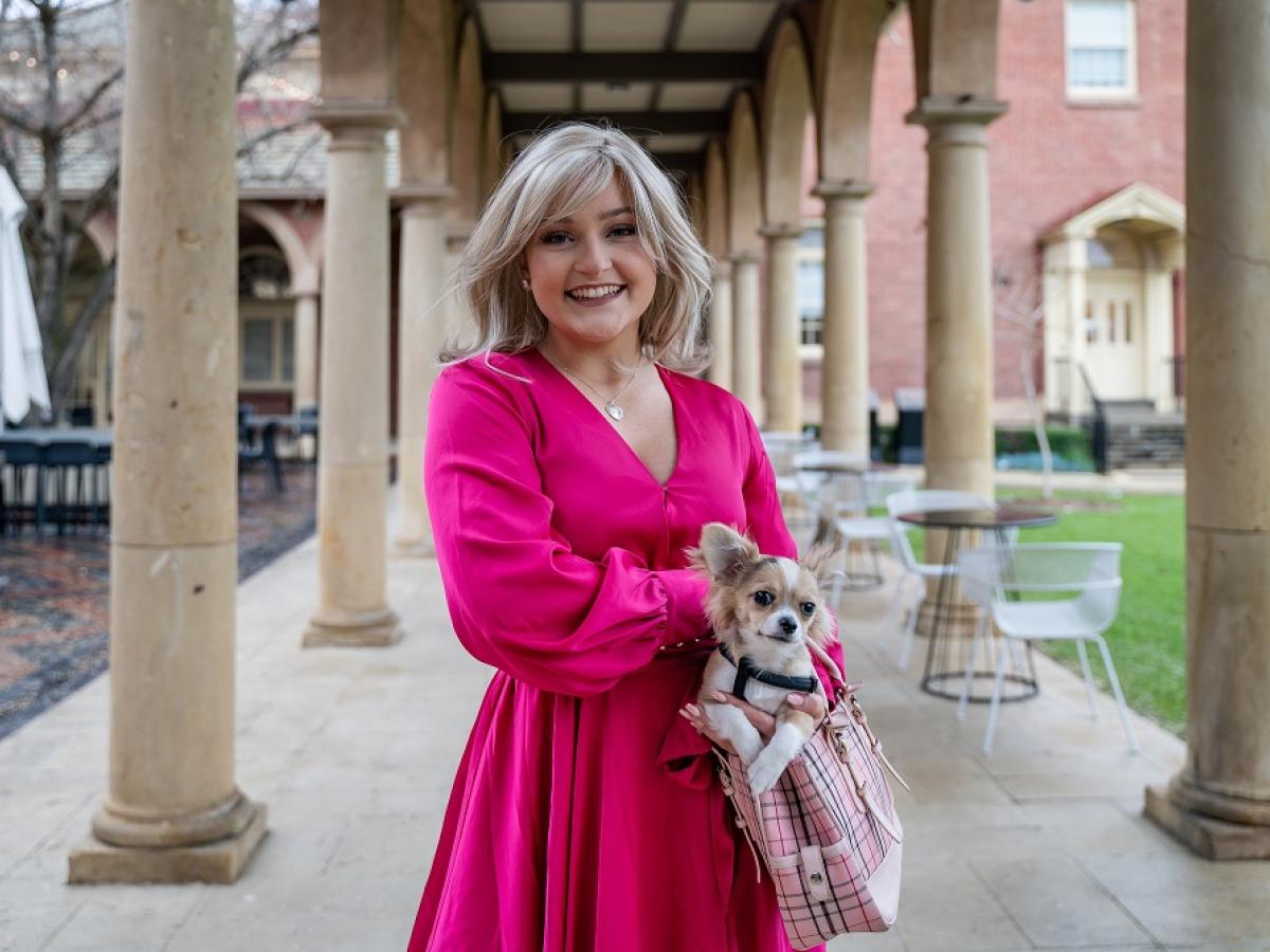 April Beak, playing Elle Woods, holds a Chihuahua in her handbag.