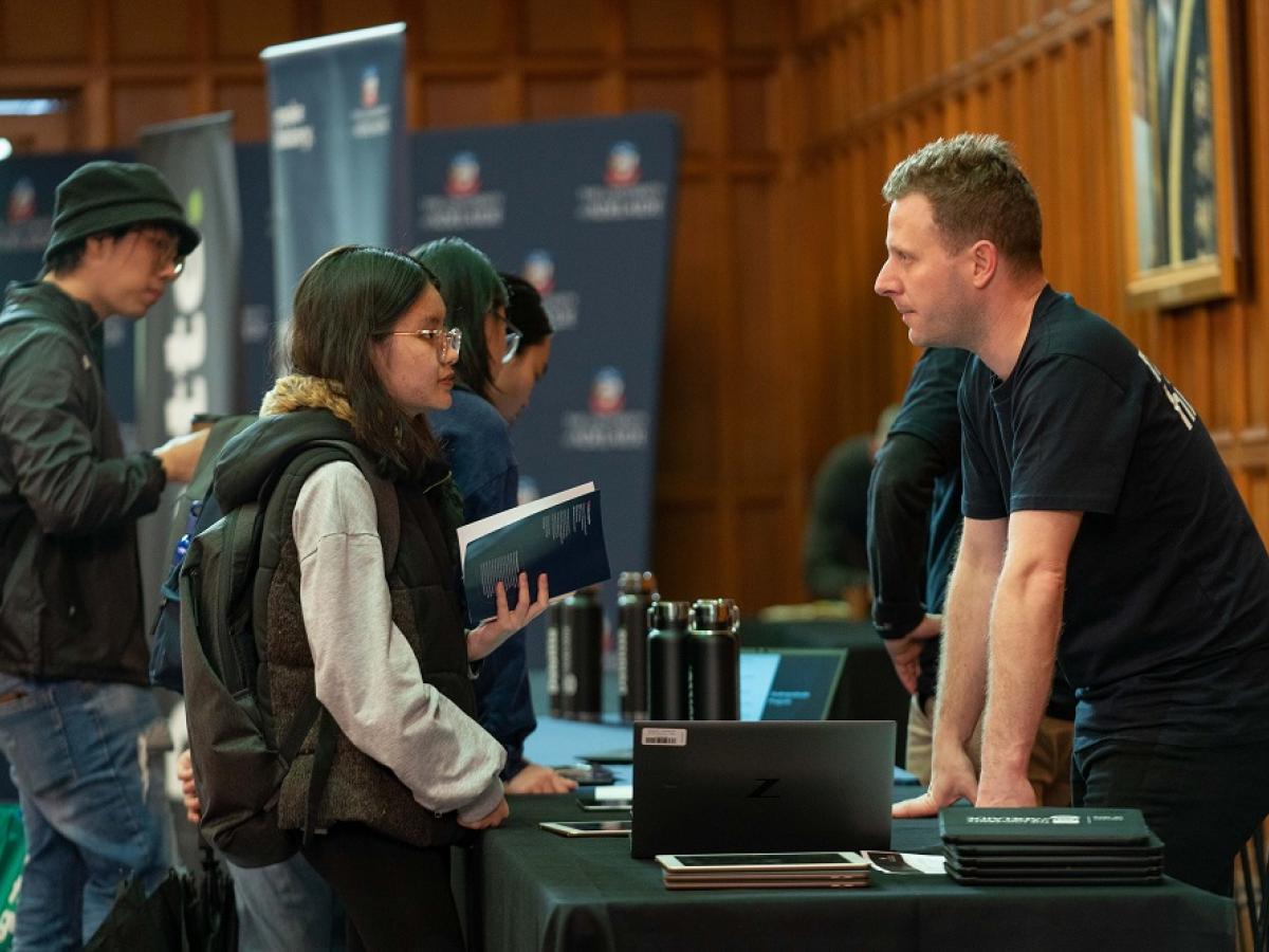 A female student speaks to a Deloitte consultant.