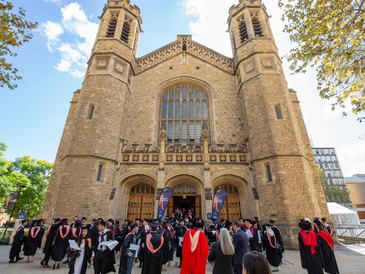 A group of people in graduation robes, outside Bonython Hall at the University of Adelaide.