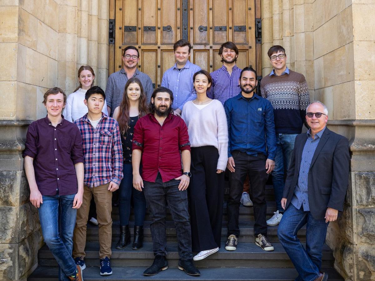 Twelve members of the Elder Conservatorium Guitar Ensemble stand in front of Elder Hall.