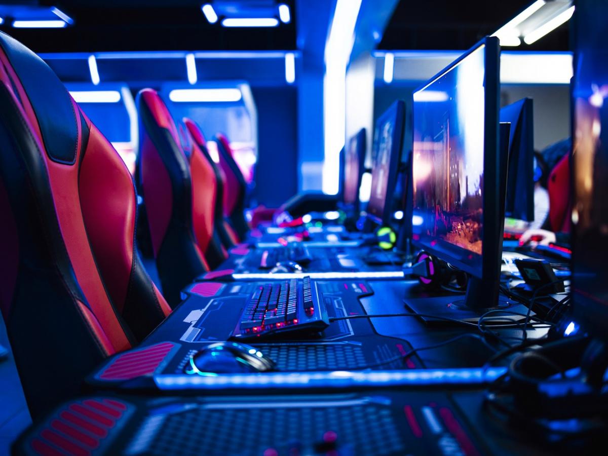 Gaming computers and chairs set up in a line.