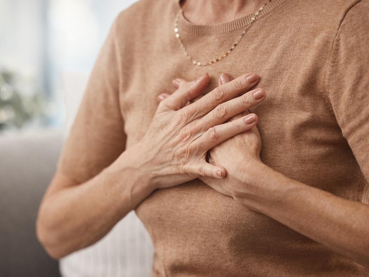 A woman clutches her chest.