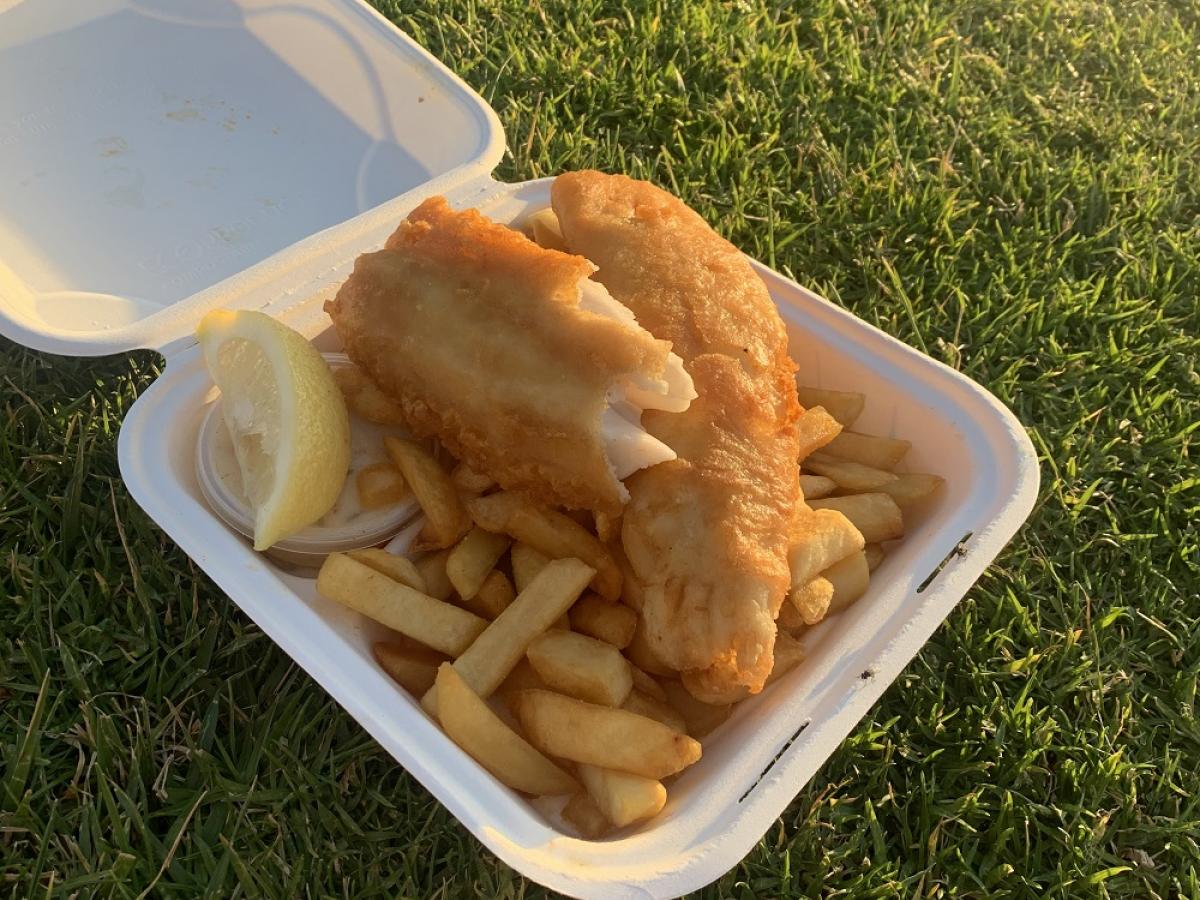Takeaway fish and chips with a lemon.