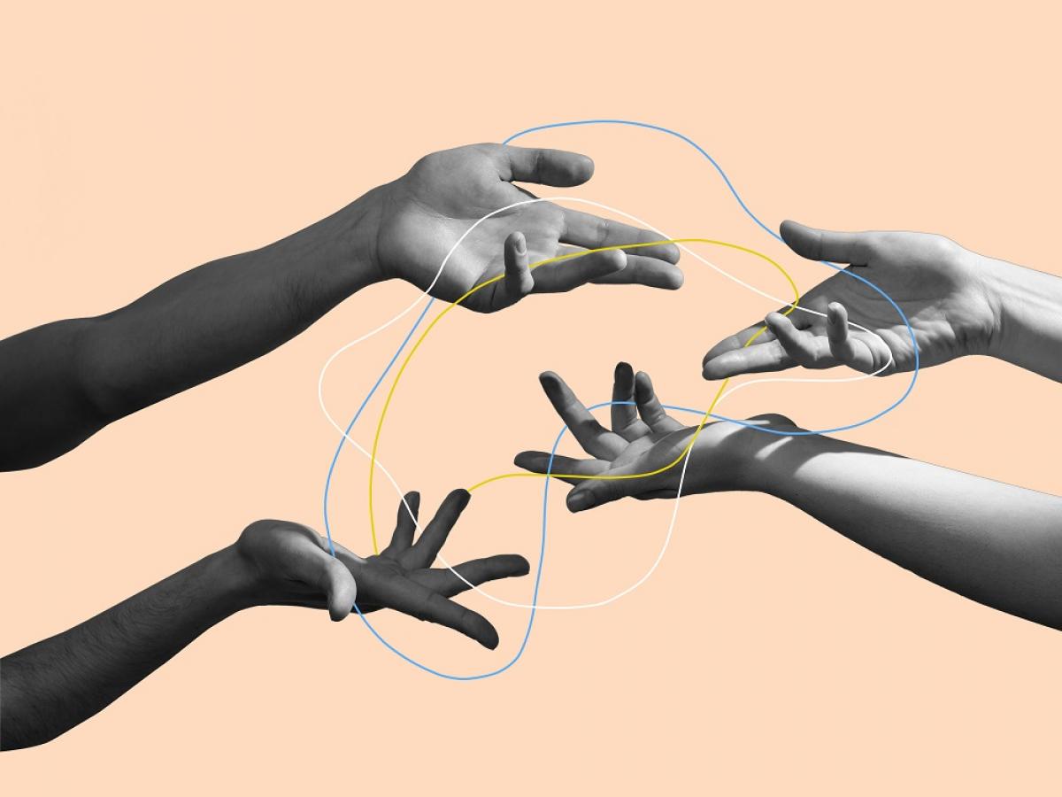 Four hands reach out to each other.