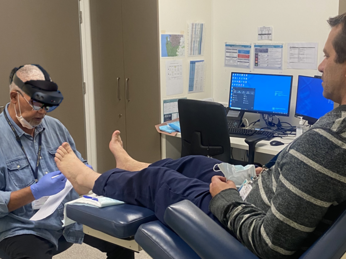 Doctor wearing smart glasses looking at patient's foot