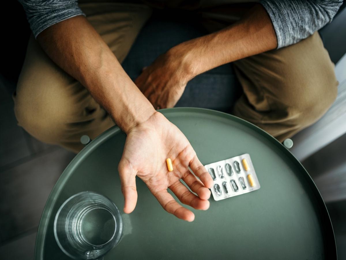 Photo of young man holding pills