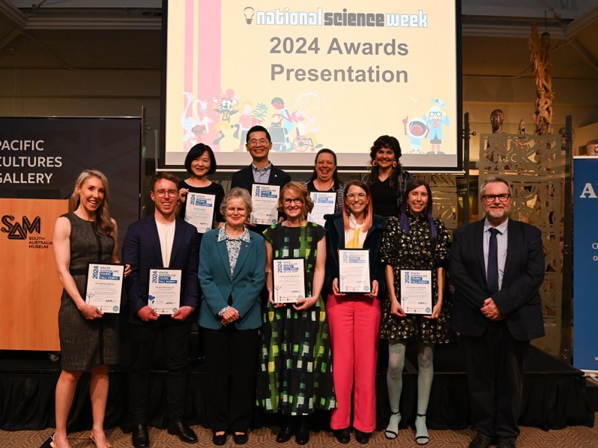 A group of 11 people stand with certificates after receiving Young Tall Poppy Awards