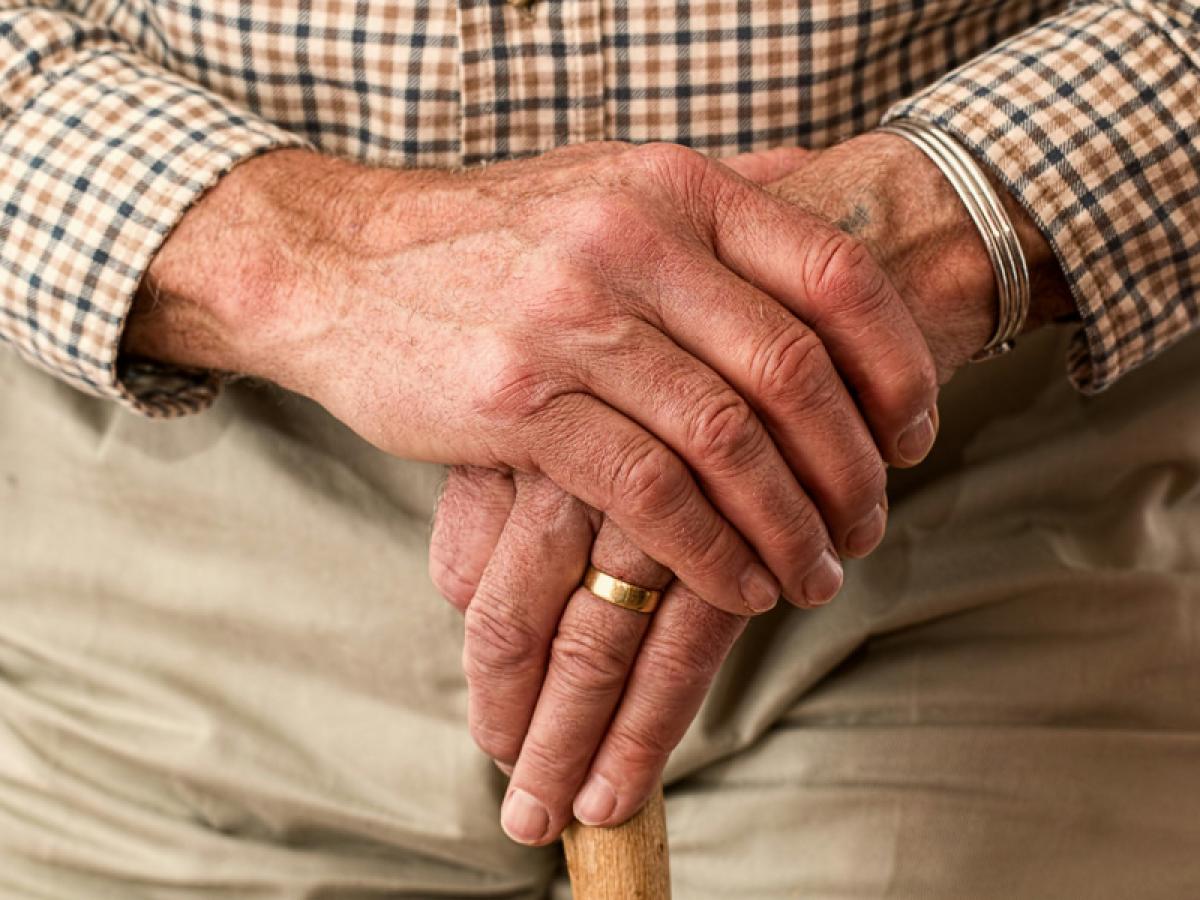 A man holds a walking stick