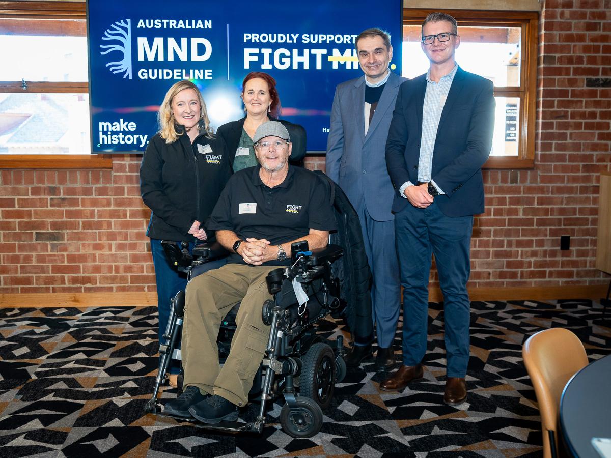 A group of five people stand at the kick-off event for National MND Guidelines