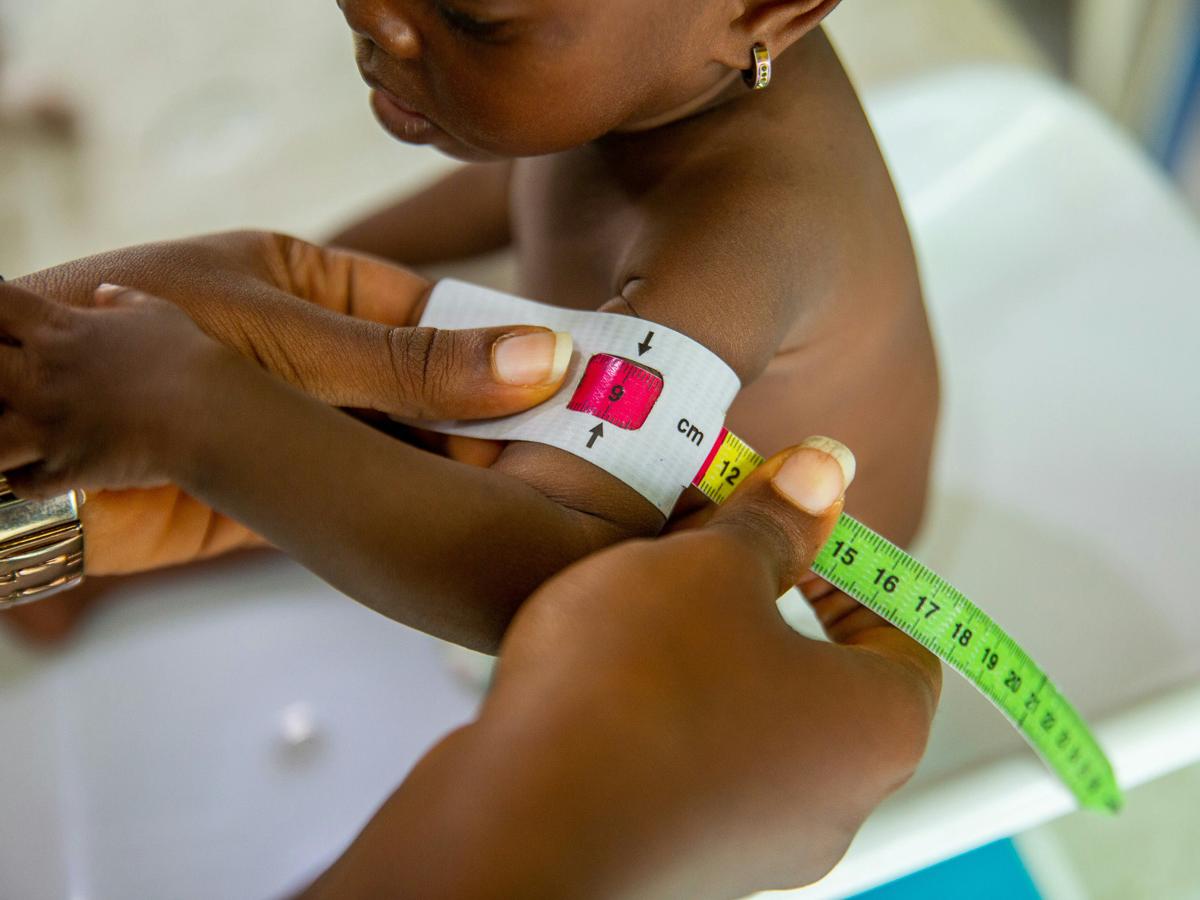 A child has its arms measured to test for malnutrition.
