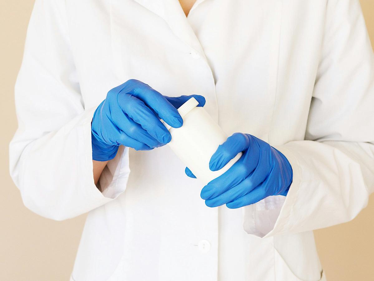 A person opens a jar of medication.