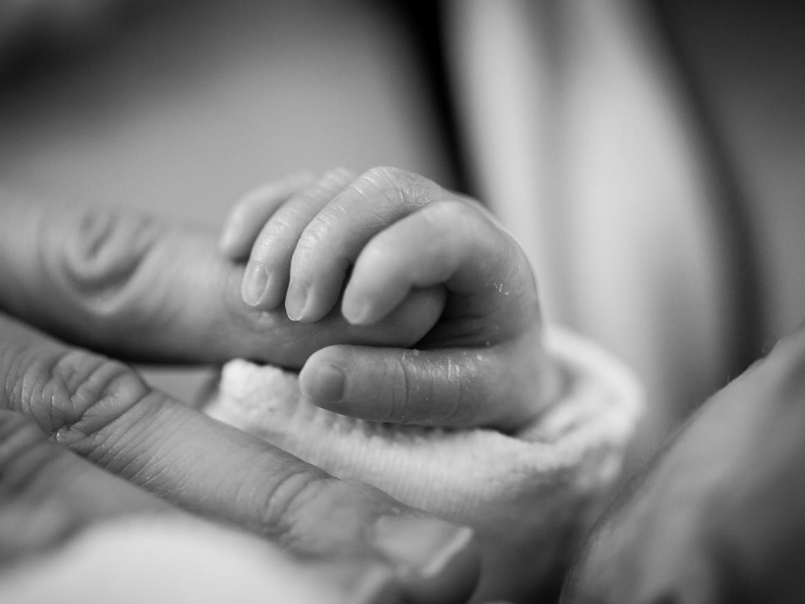 Image of a baby's hand holding a parent finger