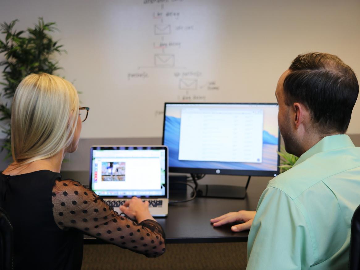 Image of two people looking at a computer screen