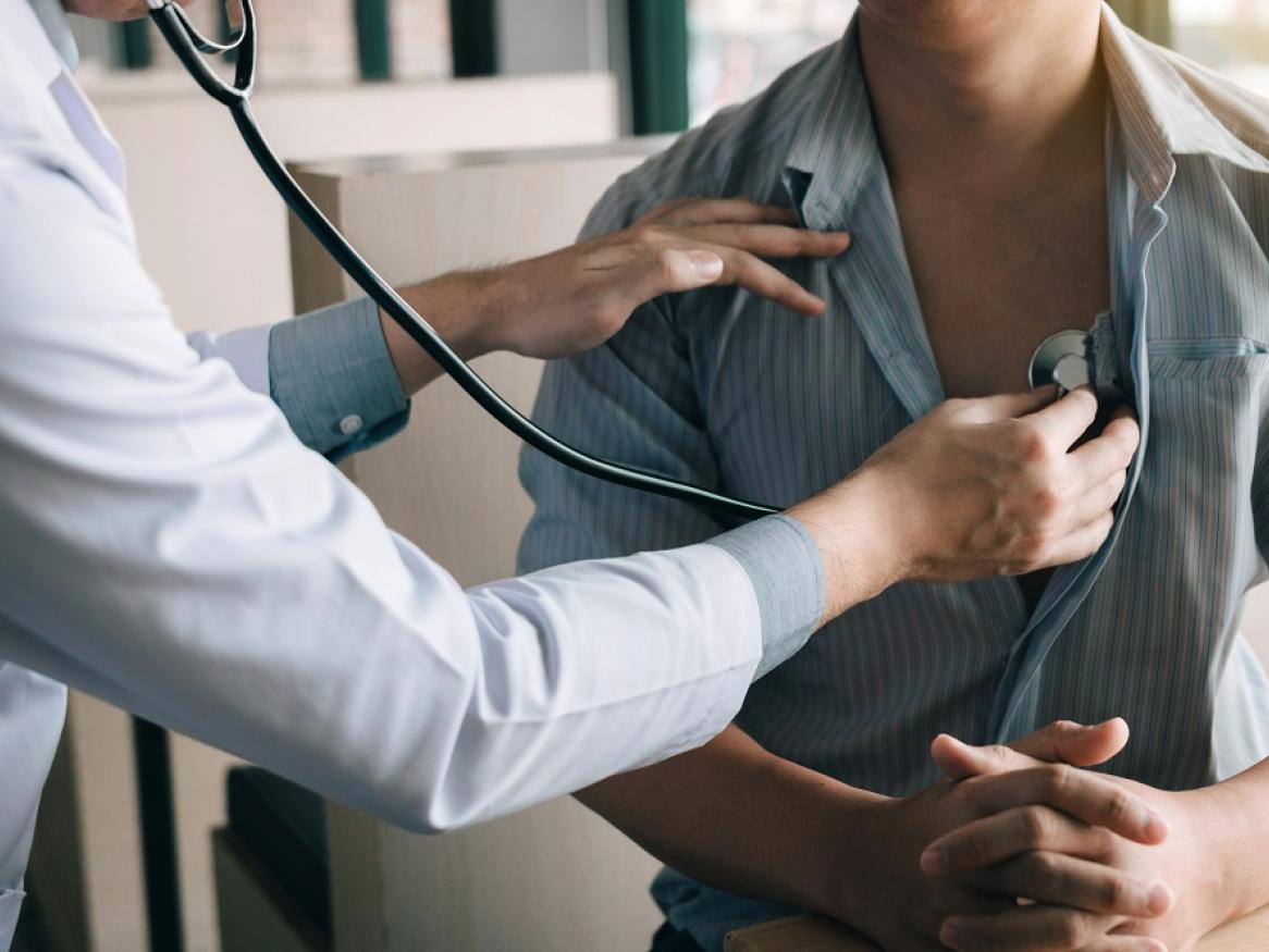 A doctor uses a stethoscope to listen to a patient's heart.