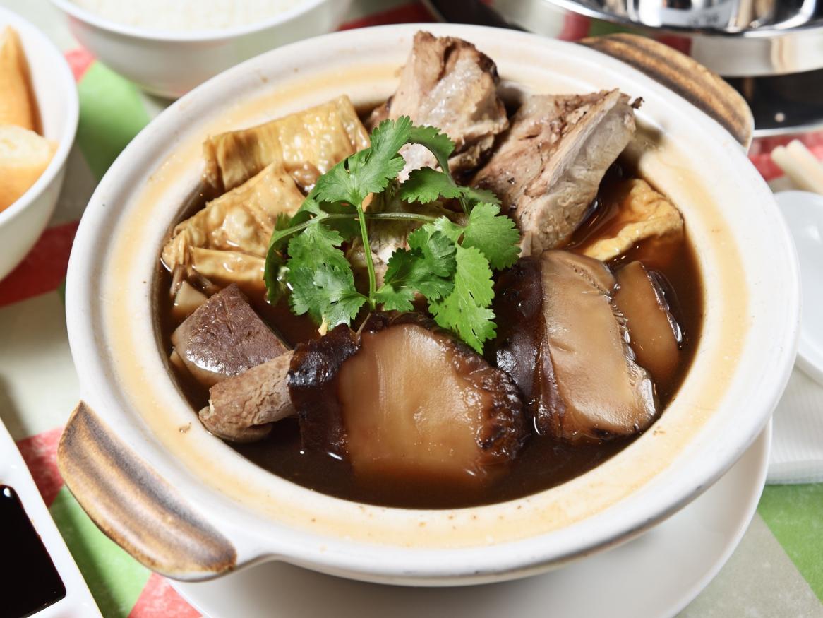 A photo of soup in a bowl, atop a table.