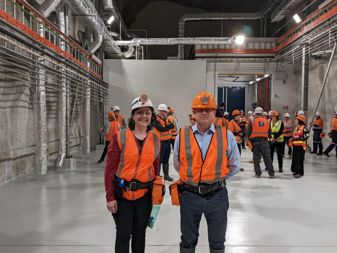 Tony Williams and Anita Vecchies in hard hats and hi-vis, smiling into the camera.