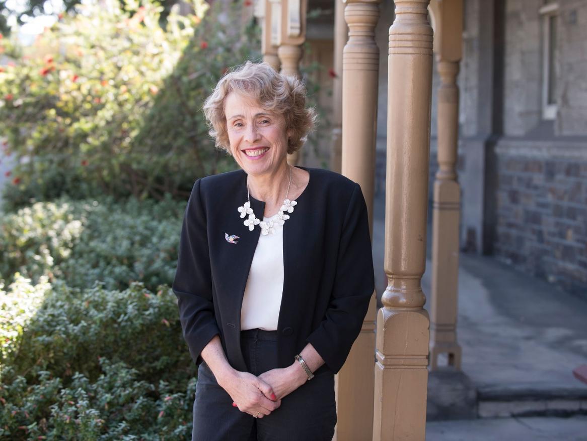 Professor Jennifer Couper stands and smiles.