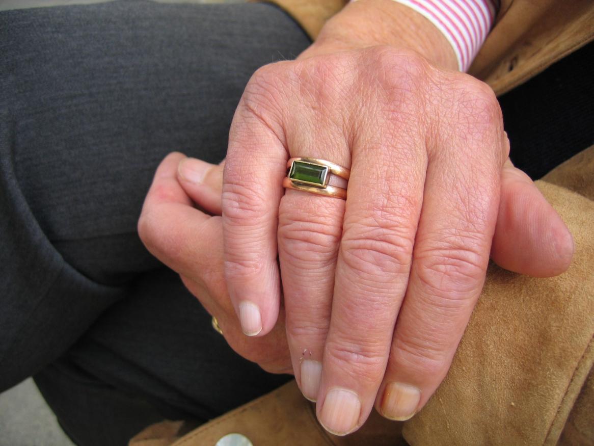 Elderly people hold hands.
