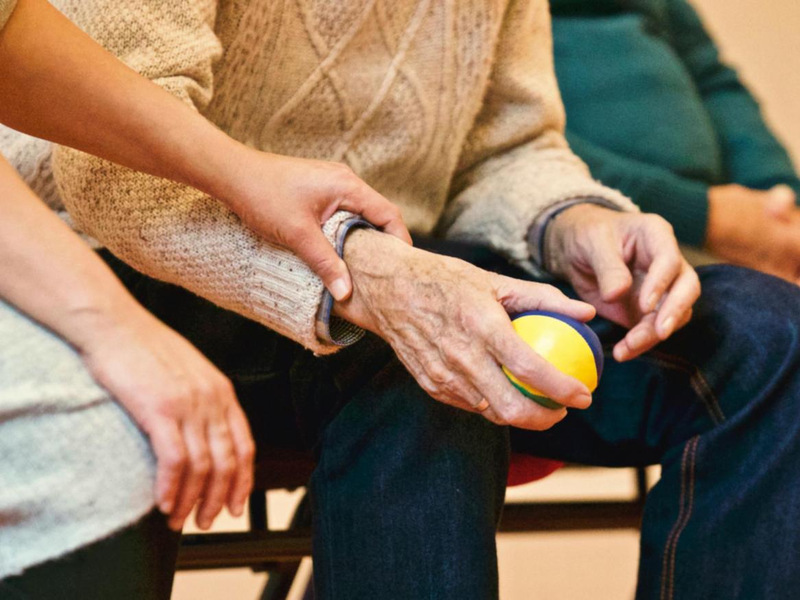 Three people sit as one holds a stress ball