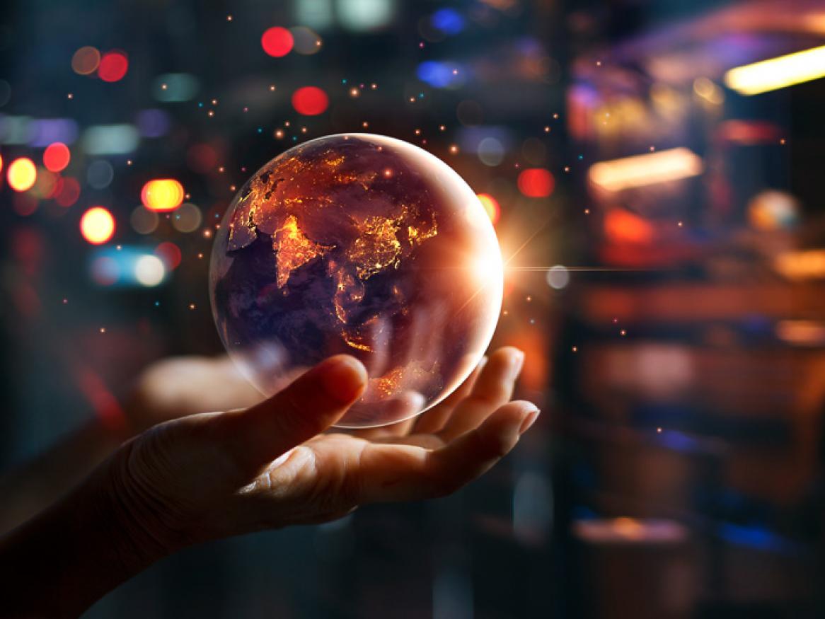 A hands hold a floating globe