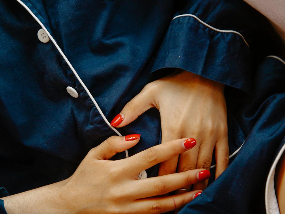 A woman clutches her stomach in pain