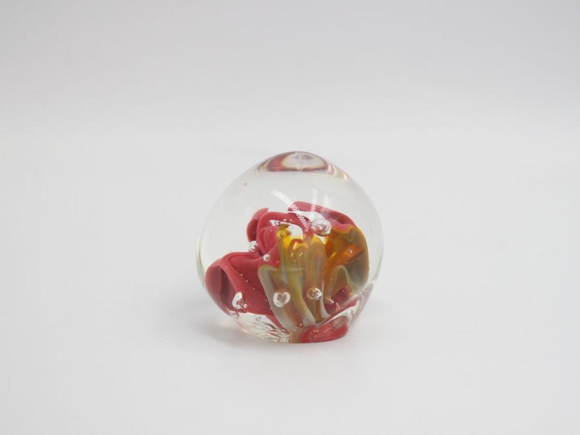 Image of a glass artwork. A glass sphere with gold and pink colours in its centre. 