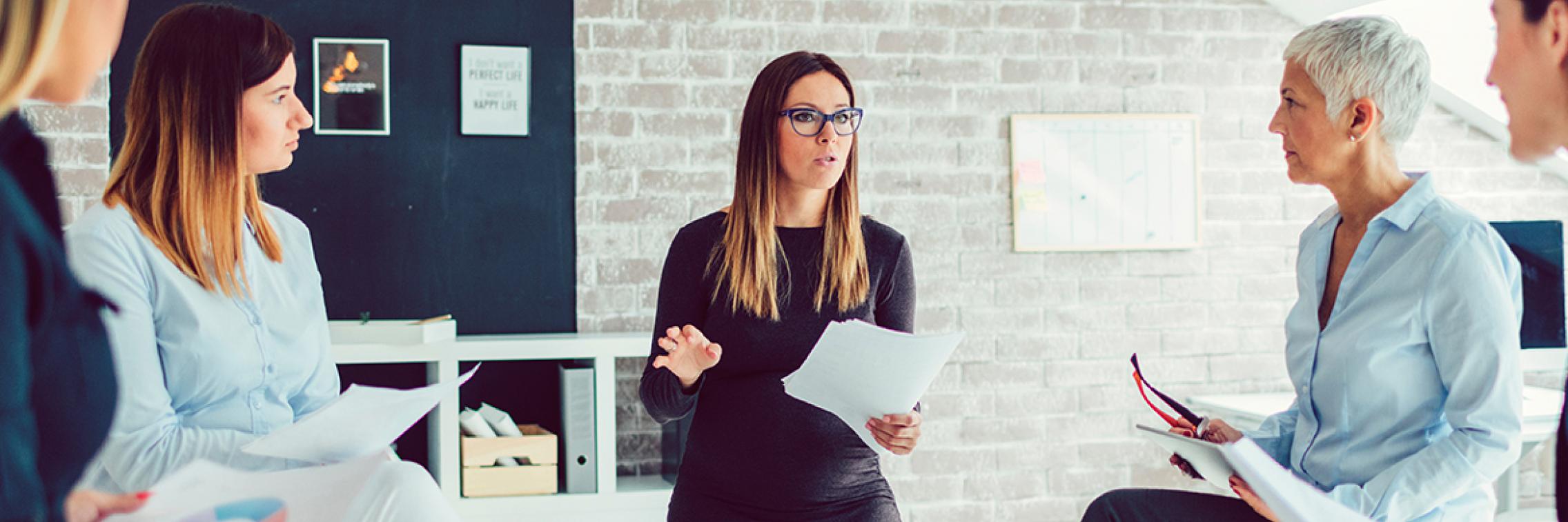 female talking to a team of people