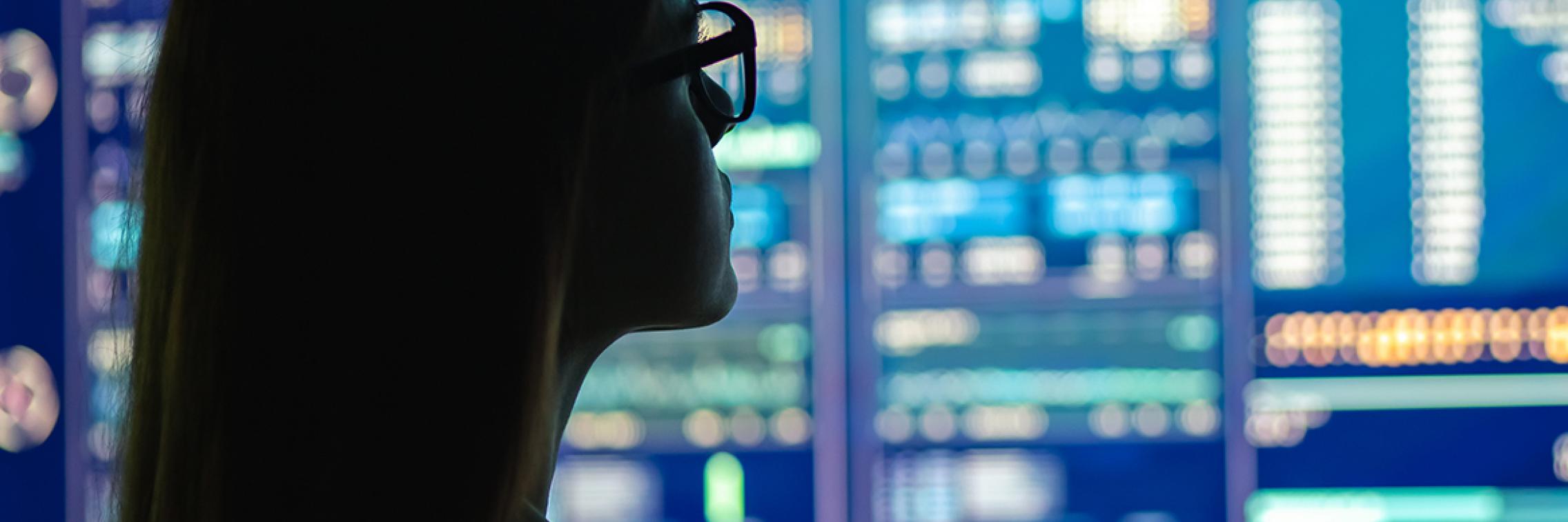 Shadow of a female looking at data on a screen