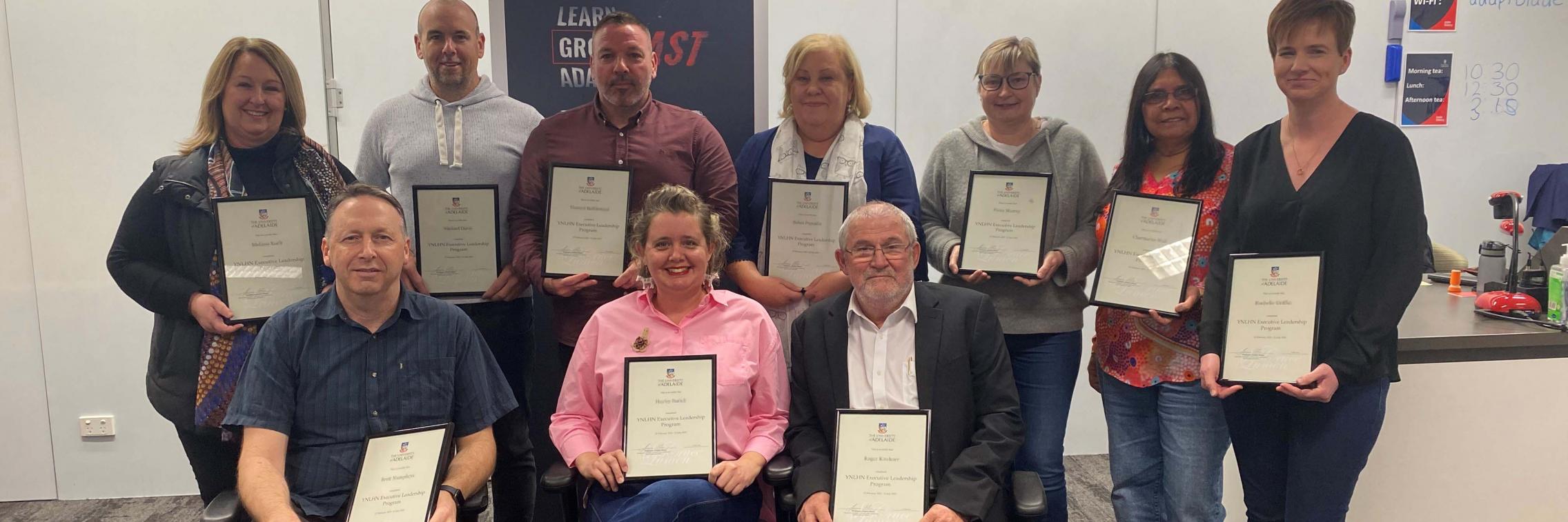A group of students holding their completion certificates
