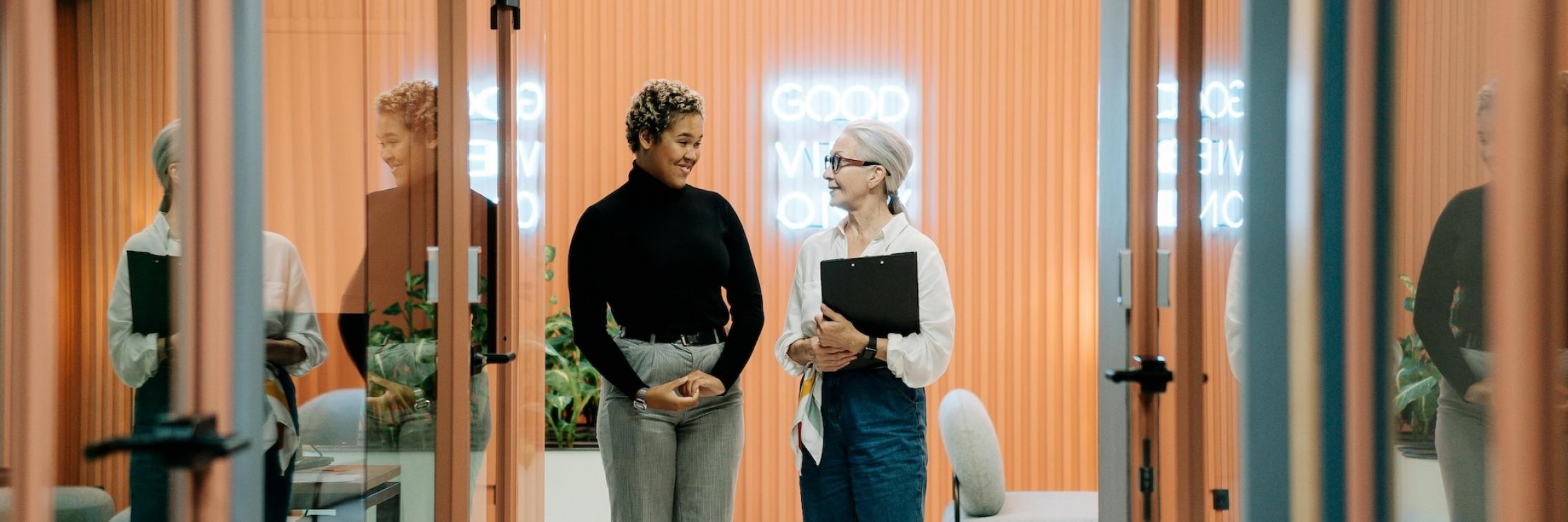 Two women talking in corridor