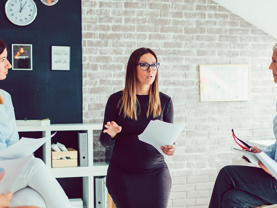 female talking to a team of people