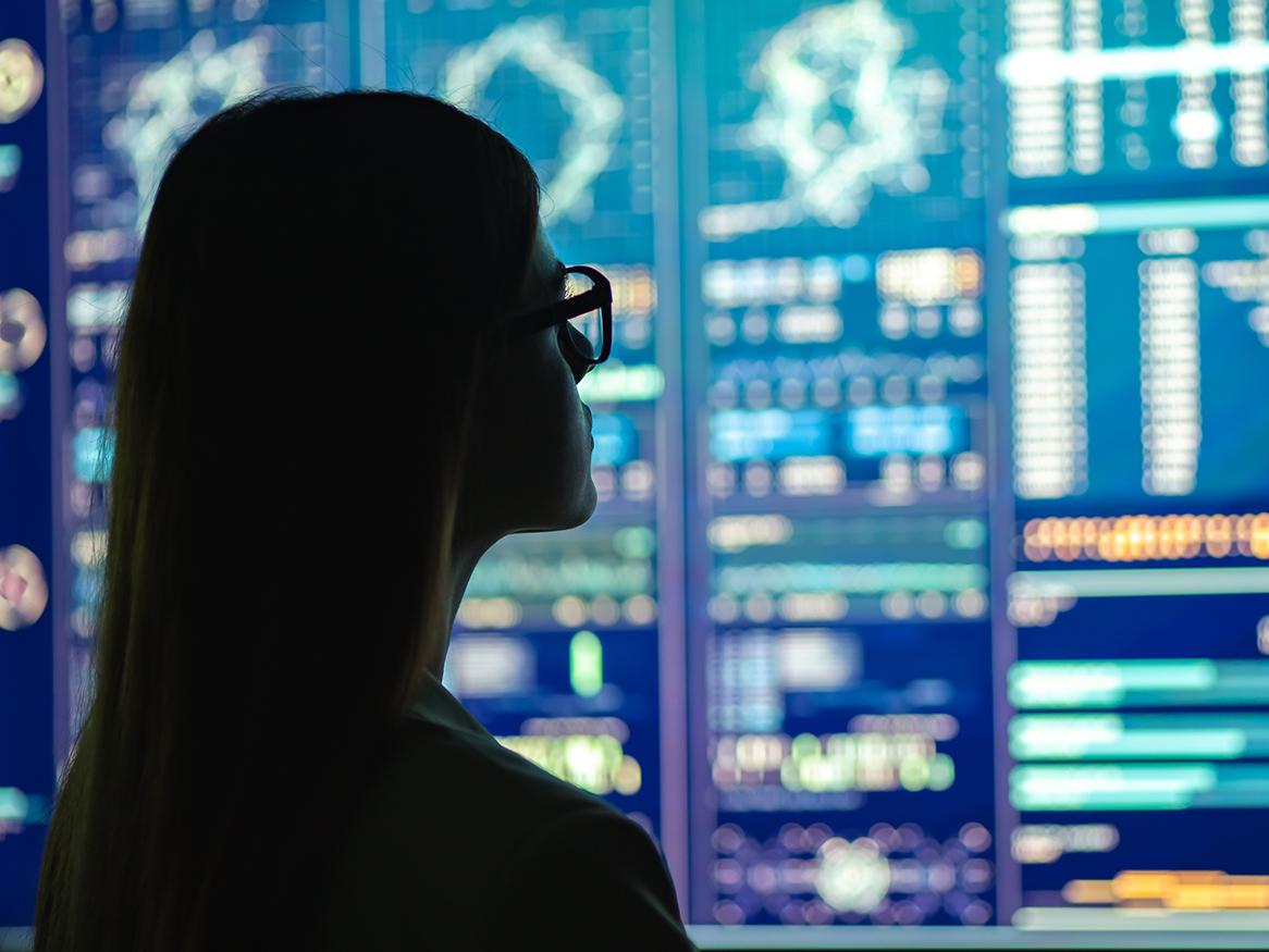 Shadow of a female looking at data on a screen